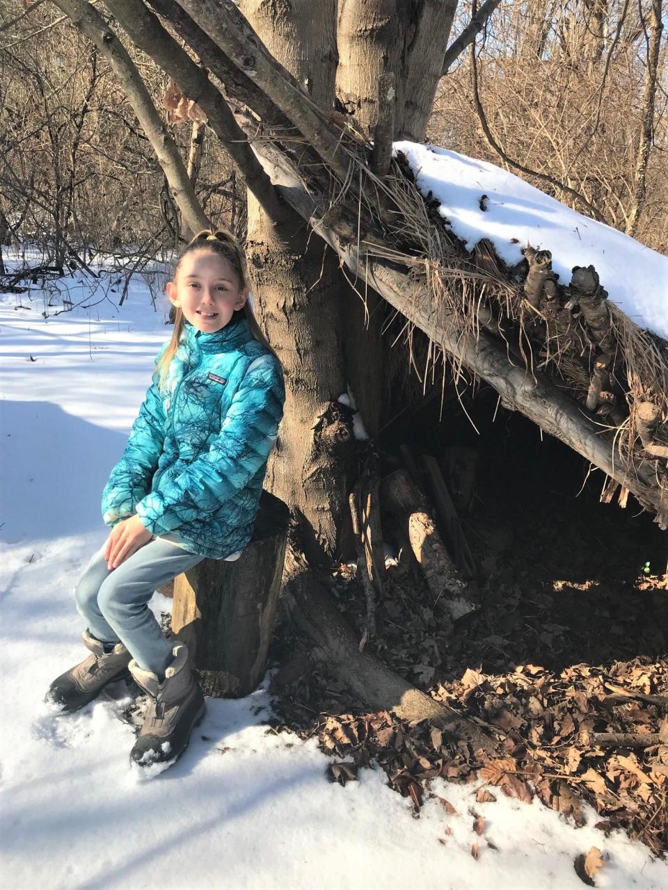Kiala Dean, 11, sits beside a shelter made of wood she built in her family's 11-acre property.