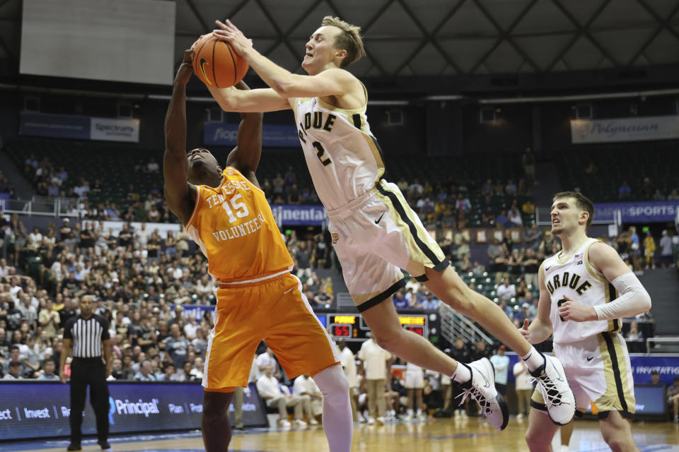 Tennessee guard Jahmai Mashack (15) and Purdue guard Fletcher Loyer (2) fight for a rebound during the second half of an NCAA college basketball game, Tuesday, Nov. 21, 2023, in Honolulu. (AP Photo/Marco Garcia)