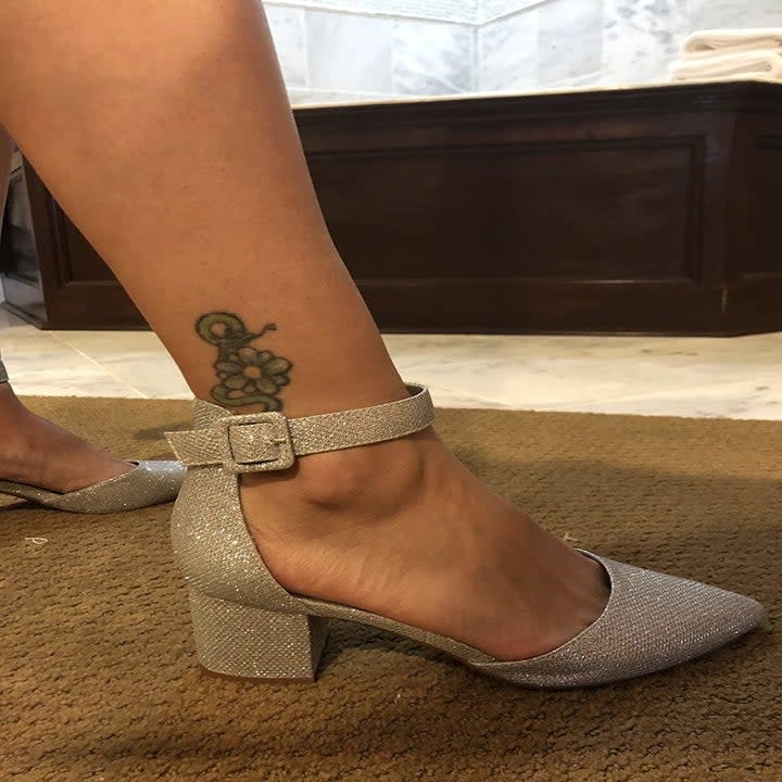 A reviewer wearing the low-heeled pumps in silver