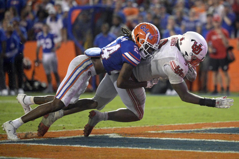 Utah running back Tavion Thomas (9) scores a touchdown on a 4-yard run as Florida cornerback Avery Helm (24) defends during the second half of an NCAA college football game Saturday, Sept. 3, 2022, in Gainesville, Fla. (AP Photo/Phelan M. Ebenhack)