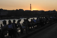 People enjoy drinks along the Seine river bank duringsun set in Paris, Thursday, Sept. 17, 2020. Health Minister Olivier Veran announced 20 more testing centers nationwide as he told a press conference that the virus is "very active again" in France. Eiffel Tower in the background. (AP Photo/Michel Euler)