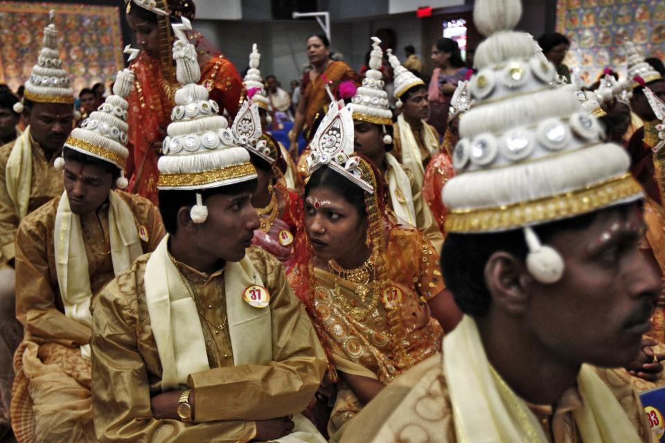 Brides and grooms speak before the start of a mass marriage ceremony in Kolkata June 18, 2014. A total of 65 Hindu couples from various villages across the eastern Indian state of West Bengal, took wedding vows on Wednesday during the day-long mass marriage ceremony organised by a philanthropic organisation, organisers said. REUTERS/Rupak De Chowdhuri (INDIA - Tags: SOCIETY)