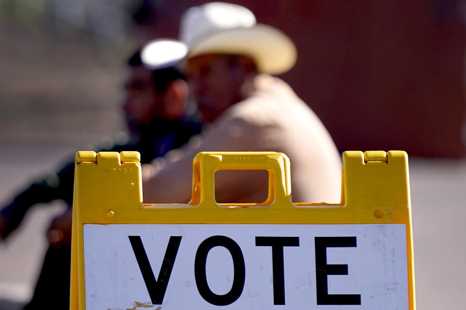 FILE - Guadalupe residents sit outside a polling station, Tuesday, Nov. 8, 2022, in Guadalupe, Ariz. On Friday, Dec. 9, 2022, The Associated Press reported on stories circulating online incorrectly claiming Arizona has 9,871,525 registered voters but its population is 7,270,000. (AP Photo/Matt York, File)