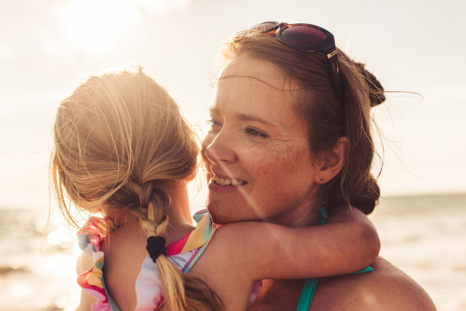 Close-up of a woman holding a little girl on a beach