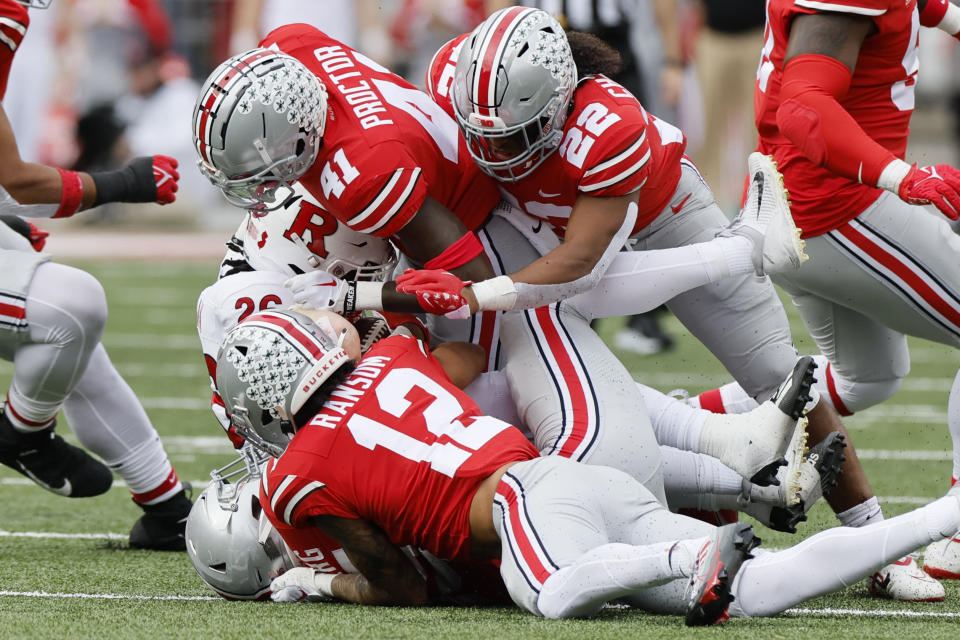 Ohio State defensive back Josh Proctor, top, linebacker Steele Chambers, right, and defensive back Lathan Ransom, front, tackle Rutgers running back Al-Shadee Salaam during the first half of an NCAA college football game Saturday, Oct. 1, 2022, in Columbus, Ohio. (AP Photo/Jay LaPrete)