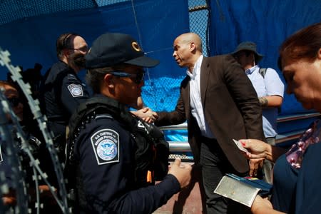 U.S. Senator (D-NJ) Cory Booker shakes hands with a CBP agent while escorting migrants seeking asylum towards El Paso, Texas, U.S., as seen at Paso del Norte border crossing bridge in Ciudad Juarez