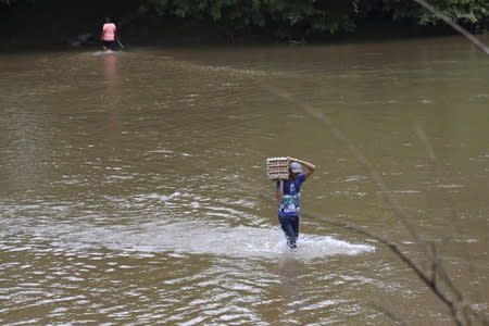 A man carries a carton of eggs across a river in the border town of Boca del Grita in the state of Tachira, Venezuela September 8, 2015. REUTERS/Girish Gupta