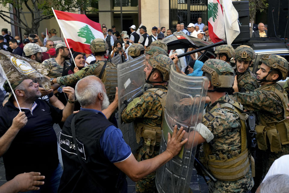 Soldiers scuffle with retired army members as they try to enter to the parliament building while the legislature was in session discussing the 2022 budget, during a protest in downtown Beirut, Lebanon, Monday, Sept. 26, 2022. The protesters demanded an increase in their monthly retirement pay, decimated during the economic meltdown. (AP Photo/Bilal Hussein)