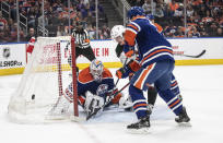 Arizona Coyotes' Josh Doan (91) is stopped by Edmonton Oilers goalie Calvin Pickard (30) as Evan Bouchard (2) defends during the first period of an NHL hockey game Friday, April 12, 2024, in Edmonton, Alberta. (Jason Franson/The Canadian Press via AP)