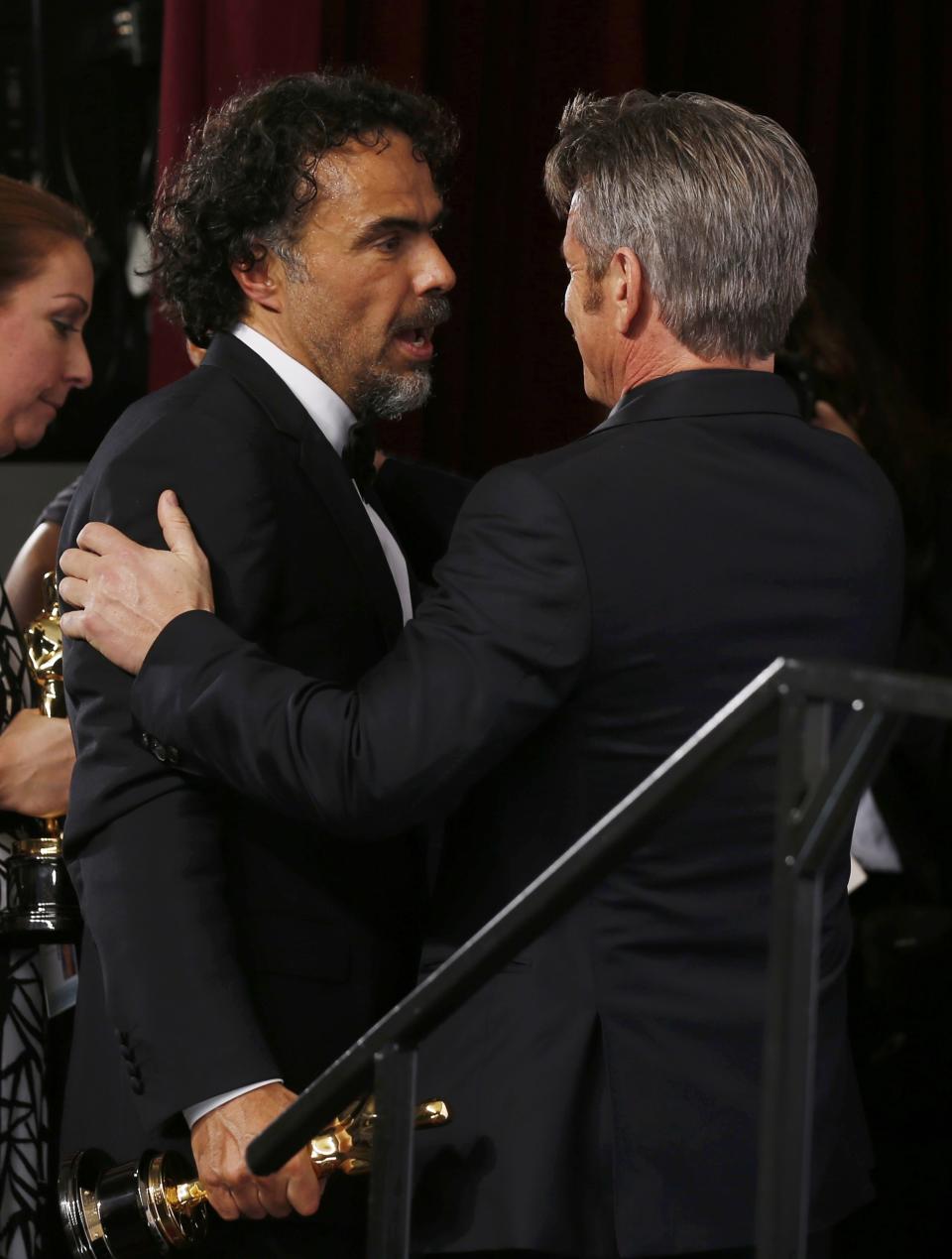 "Birdman" Director Alejandro Inarritu (L) is congratulated backstage by Best Picture presenter Sean Penn (R) after winning the Oscars for Best Director, Best Original Screenplay and Best Picture at the 87th Academy Awards in Hollywood, California February 22, 2015. REUTERS/Lucy Nicholson (UNITED STATES TAGS:ENTERTAINMENT) (OSCARS-BACKSTAGE)