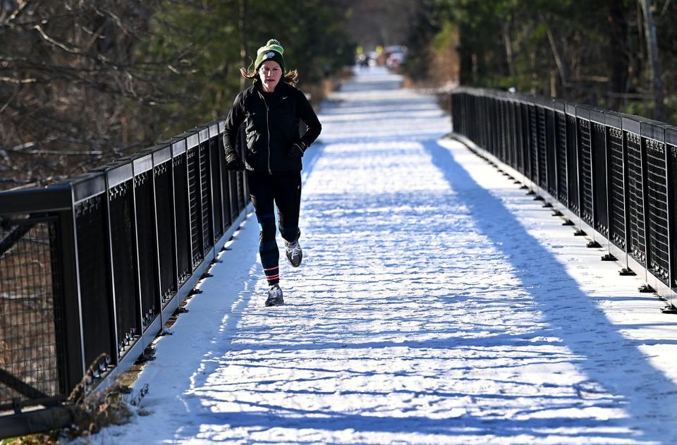 Nicole Downin, of Holliston, jogs the Holliston Rail Trail, Dec. 9, 2021.