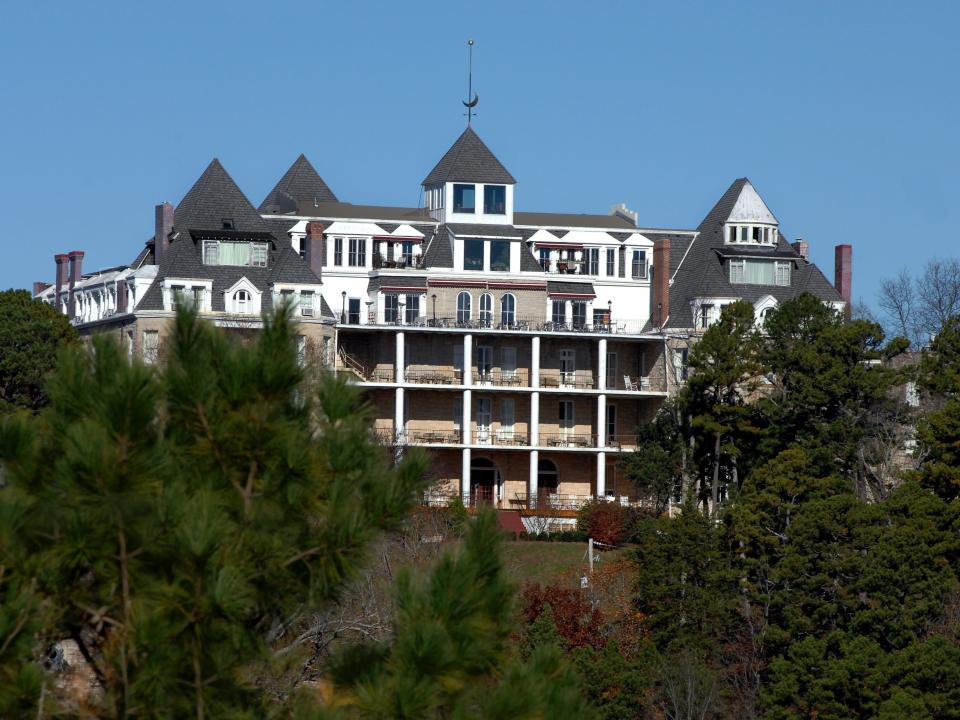 Crescent Springs Hotel peeks out between trees in Eureka, Arkansas.