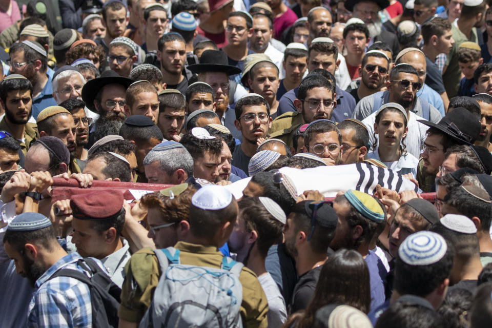 Family and friends of Yehuda Guetta carry his covered body during his funeral service in Jerusalem, Thursday, May 6, 2021. Guetta, 19, wounded in a drive-by shooting attack in the West Bank early this week died from his injuries. (AP Photo/Ariel Schalit)