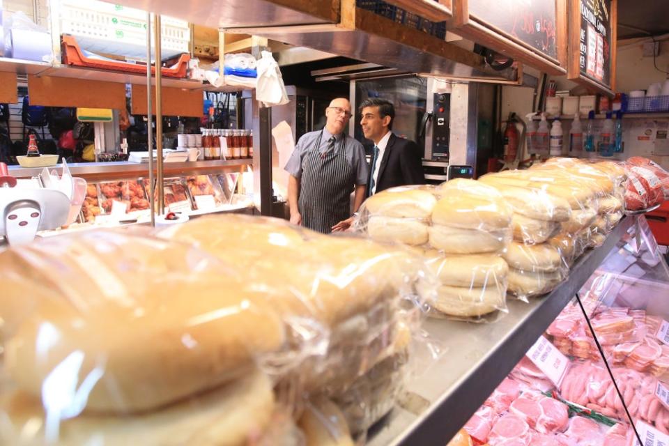 Rishi Sunak speaks to a butcher at Bury market (Lindsey Parnaby/PA) (PA Wire)