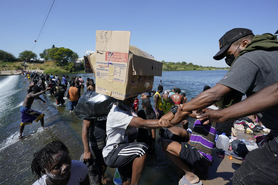 Haitian migrants use a dam to cross to and from the United States from Mexico, Friday, Sept. 17, 2021, in Del Rio, Texas. (AP Photo/Eric Gay)