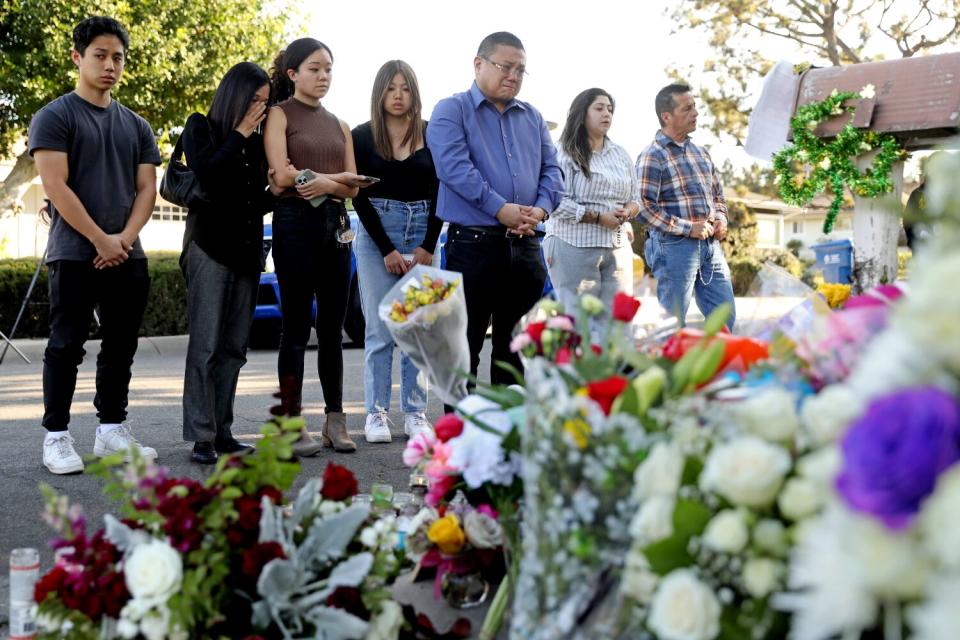 People hold a vigil outside the home of Bishop David O'Connell in Hacienda Heights.