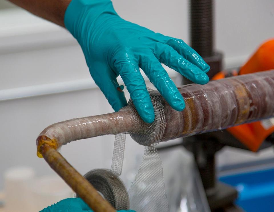 A technician insulates a component on the central solenoid by hand (General Atomics)