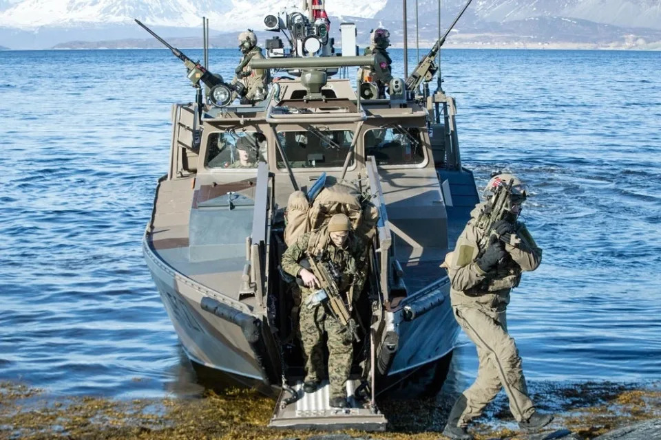 Armored US Marines disembarking a CB90 boat.