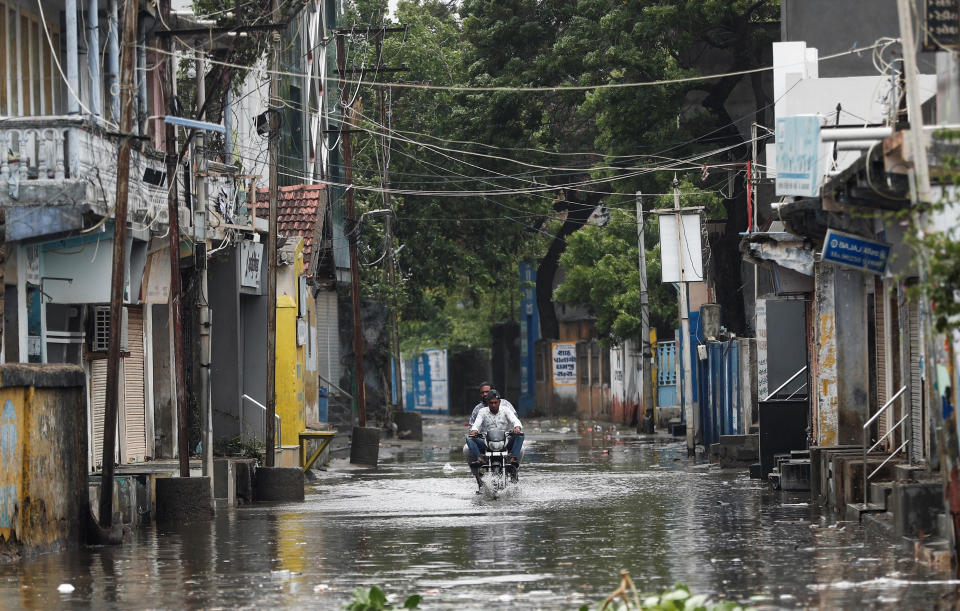 A man rides a motorcycle through a flooded street in Mandvi, India, before the arrival of Cyclone Biparjoy in the western state of Gujarat, June 15, 2023. / Credit: FRANCIS MASCARENHAS/REUTERS