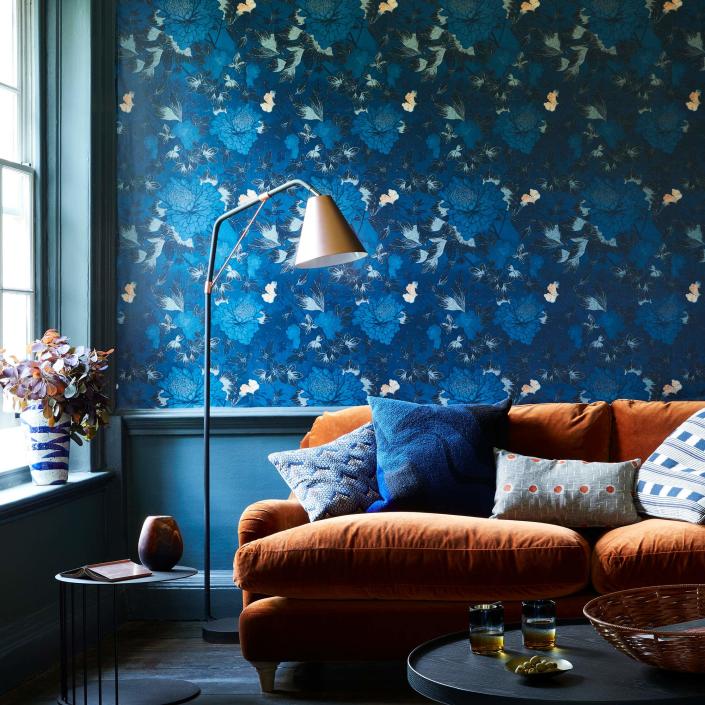 living room with blue floral printed wallpaper on wall