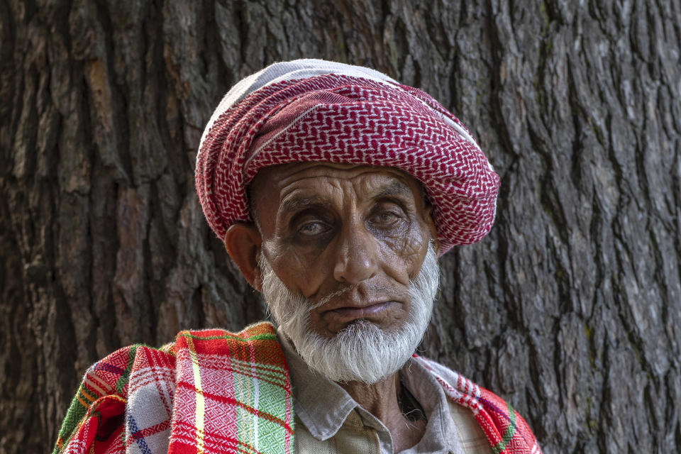 Mohammad Azam, a Kashmiri Nomadic devotee belonging to Gujjar tribe poses for a photograph outside the forest shrine of Sufi saint Mian Nizamuddin Kiyanwi in Baba Nagri, northeast of Srinagar, Indian controlled Kashmir, Saturday, June 8, 2024. Mohammad said "my beard was black when I started coming here. Now, I feel blessed to visit every year, even at this age". (AP Photo/Dar Yasin)