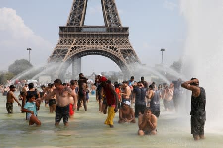 People cool off in the Trocadero fountains across from the Eiffel Tower in Paris