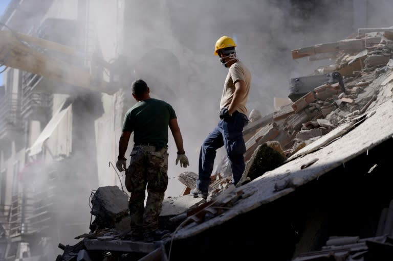 Volunteers work to move rubble and debris during search and rescue operations in Amatrice on August 24, 2016