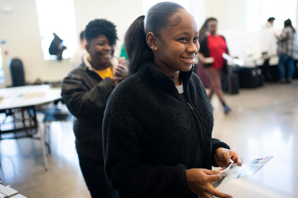 Jayden Jackson, 18, is applauded by her mom, Cathy Tolbert, and poll workers at Linden Community Center, for being a first time voter.