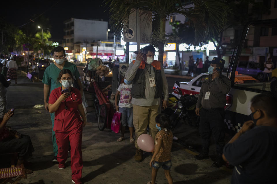 Health workers communicate on their mobile phones as they stand outside Veracruz General Hospital after a strong earthquake, in Veracruz, Mexico, Tuesday, Sept. 7, 2021. The quake struck southern Mexico near the resort of Acapulco, causing buildings to rock and sway in Mexico City nearly 200 miles away. (AP Photo/Felix Marquez)