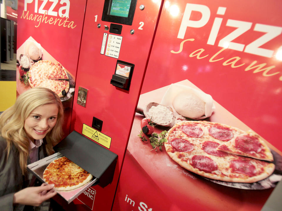 <p>Hier kommt heiße Pizza aus einem Automaten: Kunden können zwischen den Sorten Margherita und Salami wählen – die Maschine erhitzt dann das Produkt und gibt es an den Kunden aus. Den Automaten gibt es an mehreren deutschen Standorten, unter anderem an der Ruhr-Universität Bochum. (Bild: Getty Images) </p>