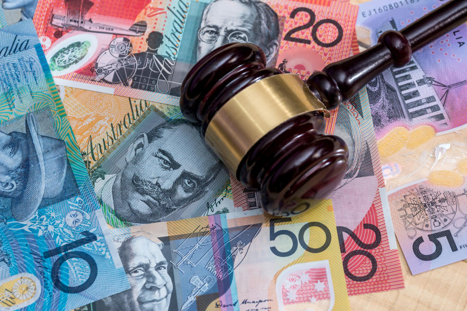 Pictured: Property auctioneer's gavel on pile of Australian cash. Image: Getty