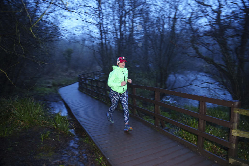 Ultra runner Helen Ryvar passes through Alyn Waters Country Park in Wrexham during running a half marathon in Wrexham, Wales, Wednesday, March 20, 2024. Helen who took up running in 2020 just before lockdown completes her daily half marathon early so as to fit in a full time job and being a single parent to 3 children. (AP Photo/Jon Super)