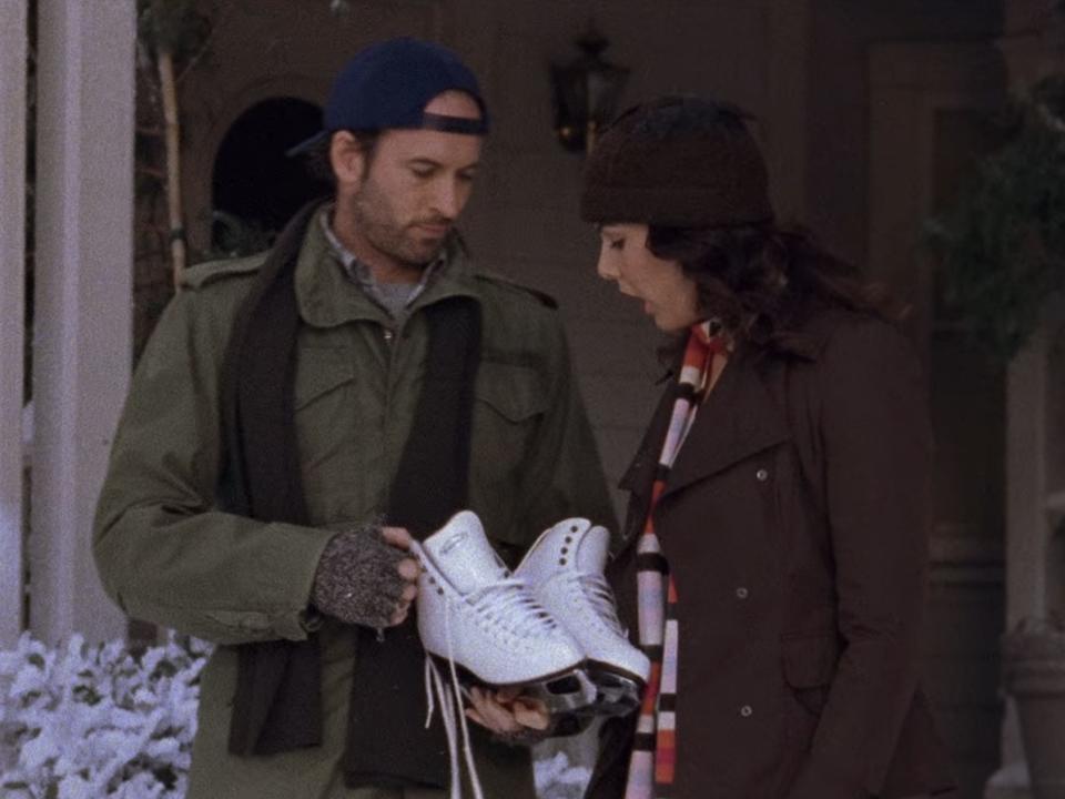 luke handing lorelai a pair of ice skates on season five of gilmore girls