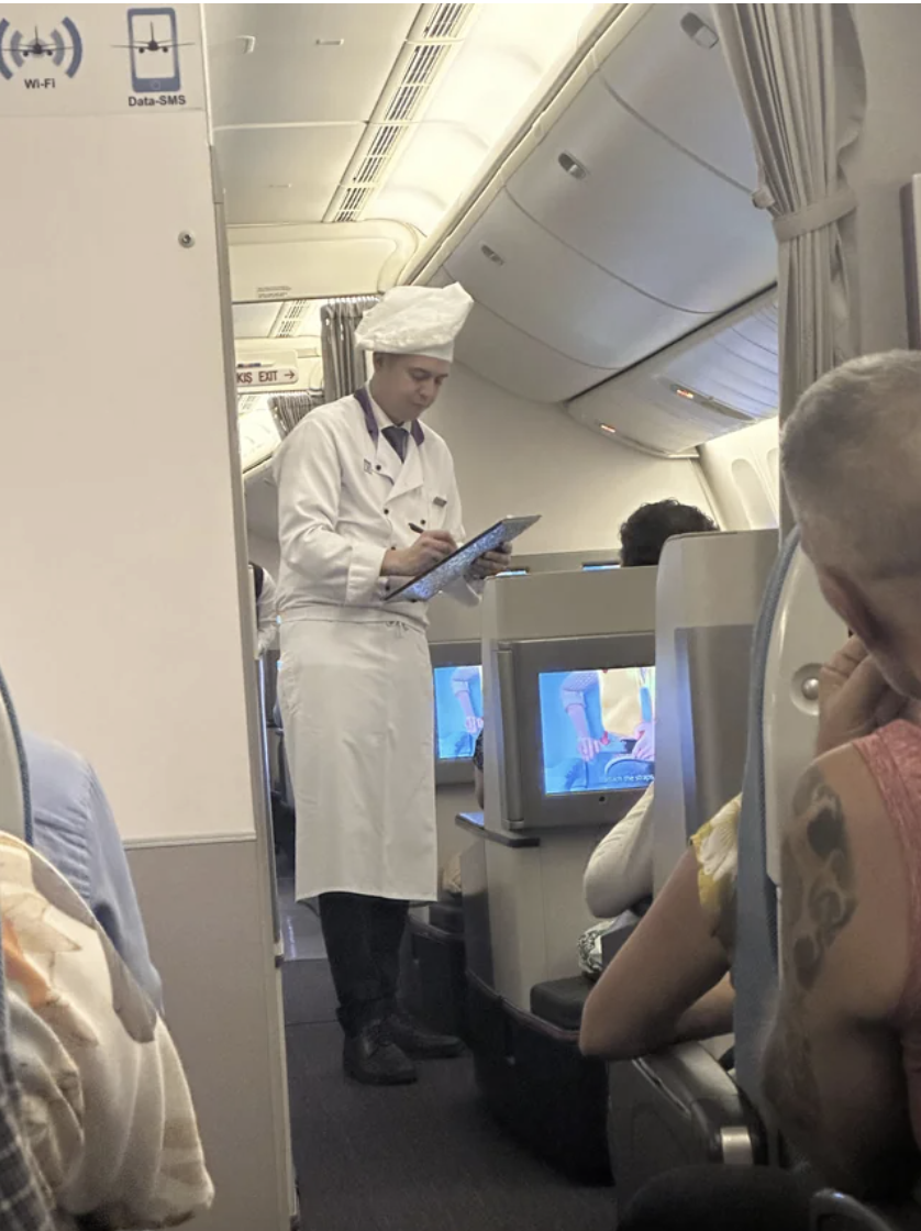 A chef taking someone's order on a plane