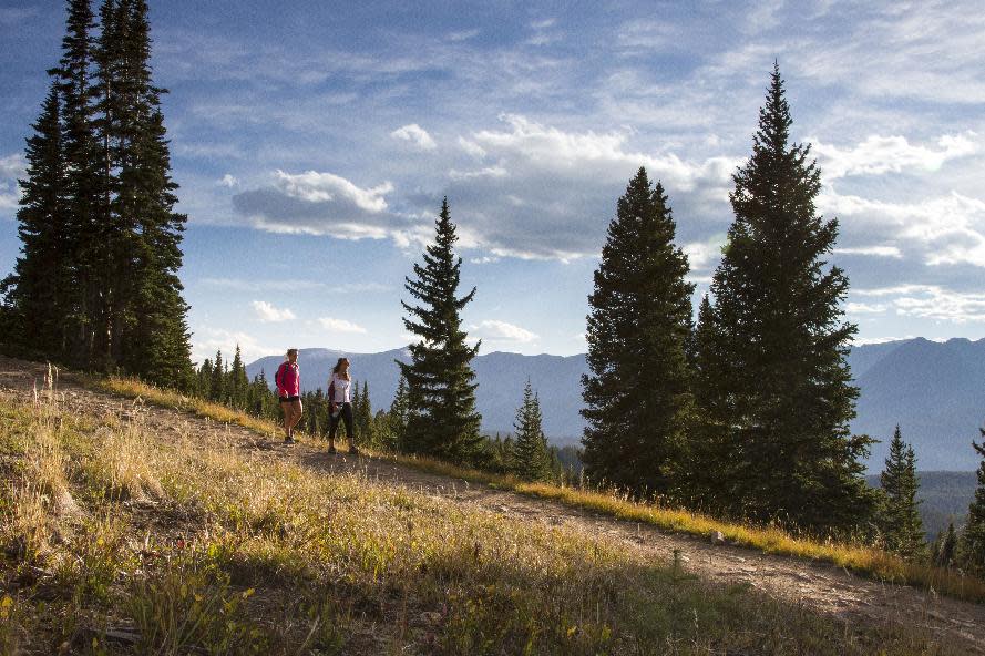 This 2012 photo provided by GoBreck shows hikers on a hilly trail in Breckenridge, Colo. Breckenridge may be best known as a ski resort but it offers many summer and fall activities for visitors, along with offseason deals. (AP Photo/GoBreck, Liam Doran)