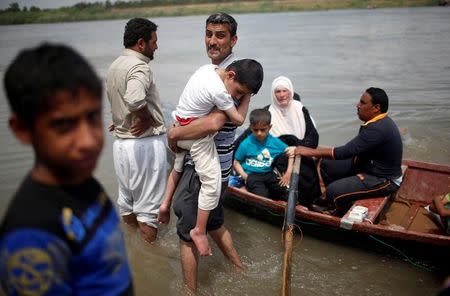 Displaced Iraqis react before crossing the Tigris River by boat after the bridge has been temporarily closed, in western Mosul, Iraq May 6, 2017. REUTERS/Suhaib Salem