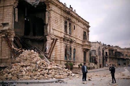 People take pictures in front of the old Customs building in the government controlled Old City of Aleppo, Syria December 17, 2016. REUTERS/Omar Sanadiki