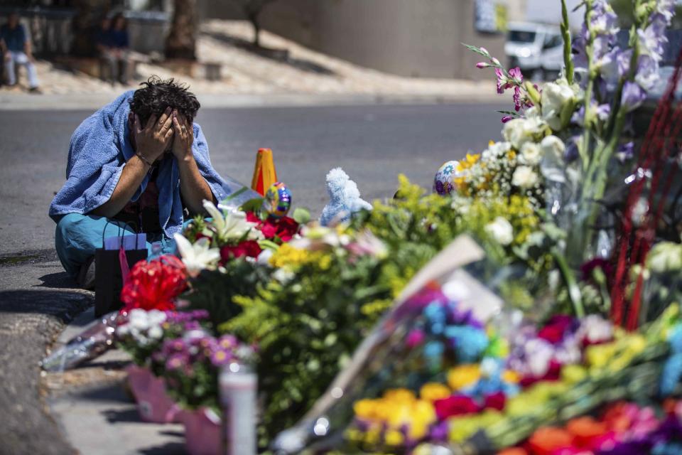 Felipe Avila puts his head in his hands as he cries Sunday, Aug. 4, 2019, in El Paso, Texas,at the place where locals came to honor the memory of the victims of the mass shooting occurred in Walmart on Saturday, Aug. 3, 2019. (Lola Gomez/Austin American-Statesman via AP)