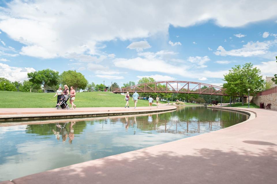 Groups of people walk around the Pueblo Riverwalk on Tuesday, May 14, 2024.