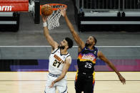 Denver Nuggets guard Jamal Murray (27) drives past Phoenix Suns forward Mikal Bridges during the first half of an NBA basketball game Saturday, Jan. 23, 2021, in Phoenix. (AP Photo/Rick Scuteri)