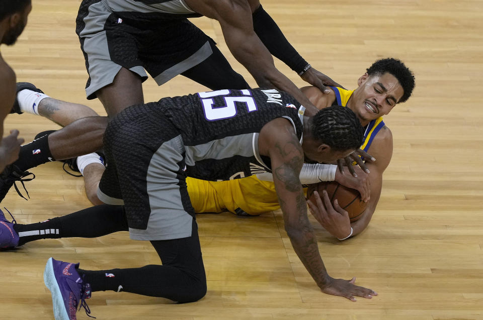 Golden State Warriors guard Jordan Poole (3) battles for a loose ball against Sacramento Kings guard Delon Wright (55) during the first half of an NBA basketball game on Sunday, April 25, 2021, in San Francisco. (AP Photo/Tony Avelar)