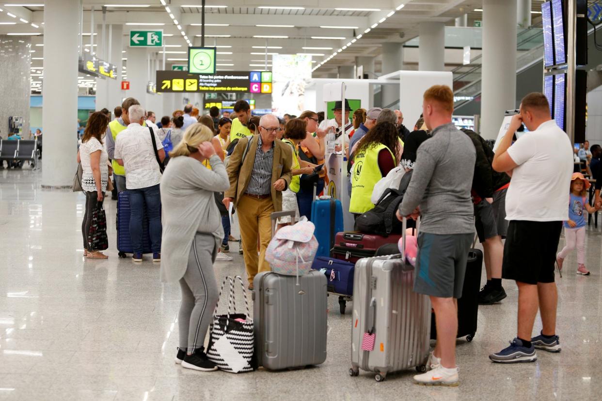 Passengers talk to Civil Aviation Authority employees at Mallorca Airport as an announcement is expected on Thomas Cook: Reuters