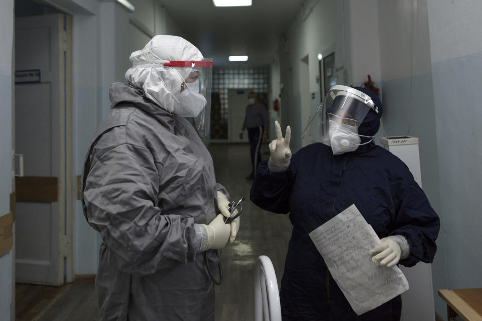 Medical workers discuss in a corridor of an intensive care unit in the red zone of the hospital in Ulan-Ude, the regional capital of Buryatia, a region near the Russia-Mongolia border, Russia, Friday, Nov. 20, 2020. Russia’s health care system has been under severe strain in recent weeks, as a resurgence of the coronavirus pandemic has swept the country. (AP Photo/Anna Ogorodnik)