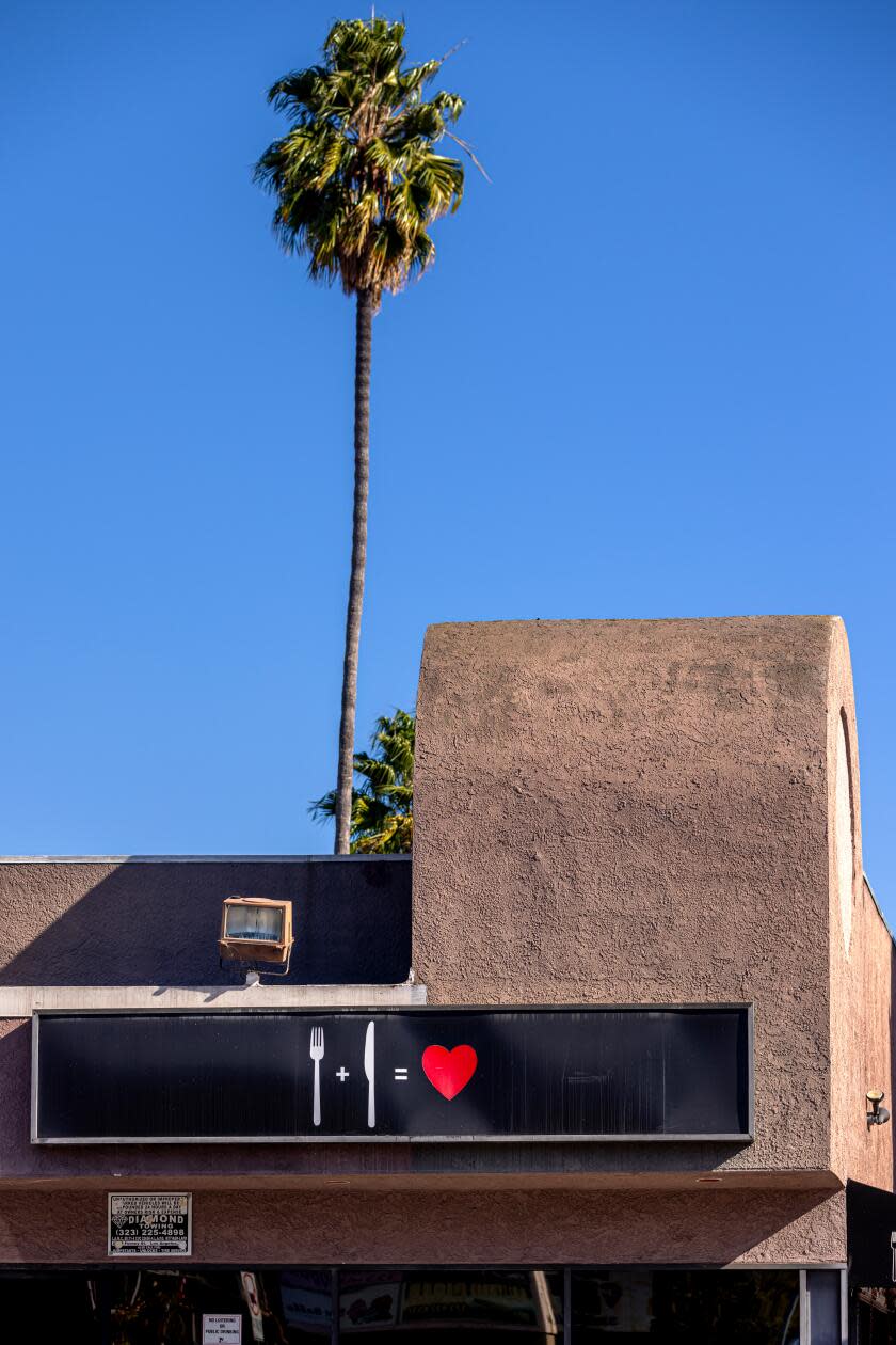 The exterior of My Two Cents, a reimagined soul food restaurant, with a palm tree behind.