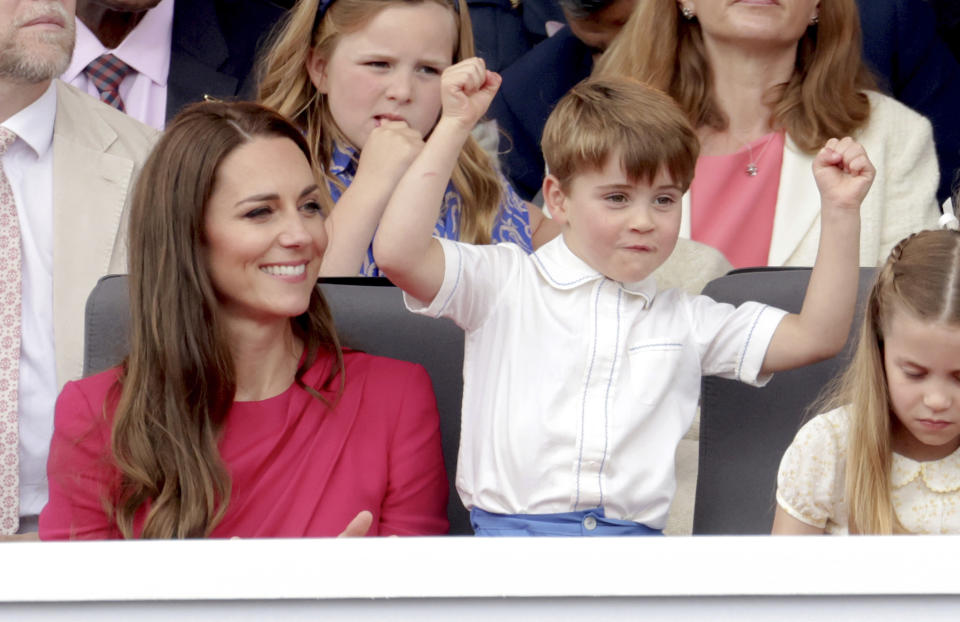 From left, Kate, Duchess of Cambridge, Prince Louis and Princess Charlotte watch, during the Platinum Jubilee Pageant held outside Buckingham Palace, in London, Sunday June 5, 2022, on the last of four days of celebrations to mark the Platinum Jubilee. The pageant will be a carnival procession up The Mall featuring giant puppets and celebrities that will depict key moments from Queen Elizabeth II’s seven decades on the throne. (Chris Jackson/Pool Photo via AP)