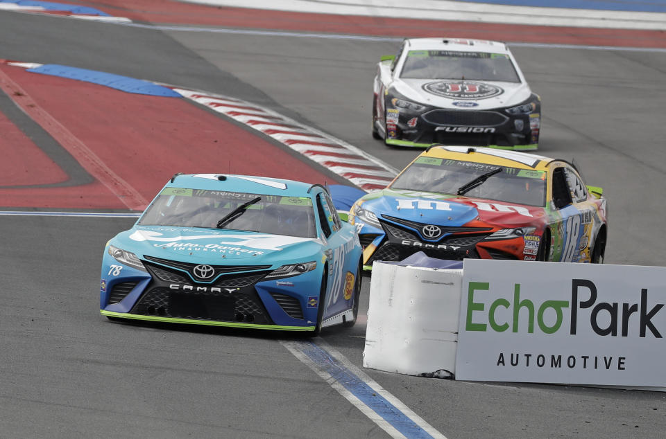 Martin Truex Jr. (78), Kyle Busch (18) and Kevin Harvick (4) come through the backstretch chicane during practice for Sunday's NASCAR Cup Series auto race at Charlotte Motor Speedway in Concord, N.C., Saturday, Sept. 29, 2018. (AP Photo/Chuck Burton)
