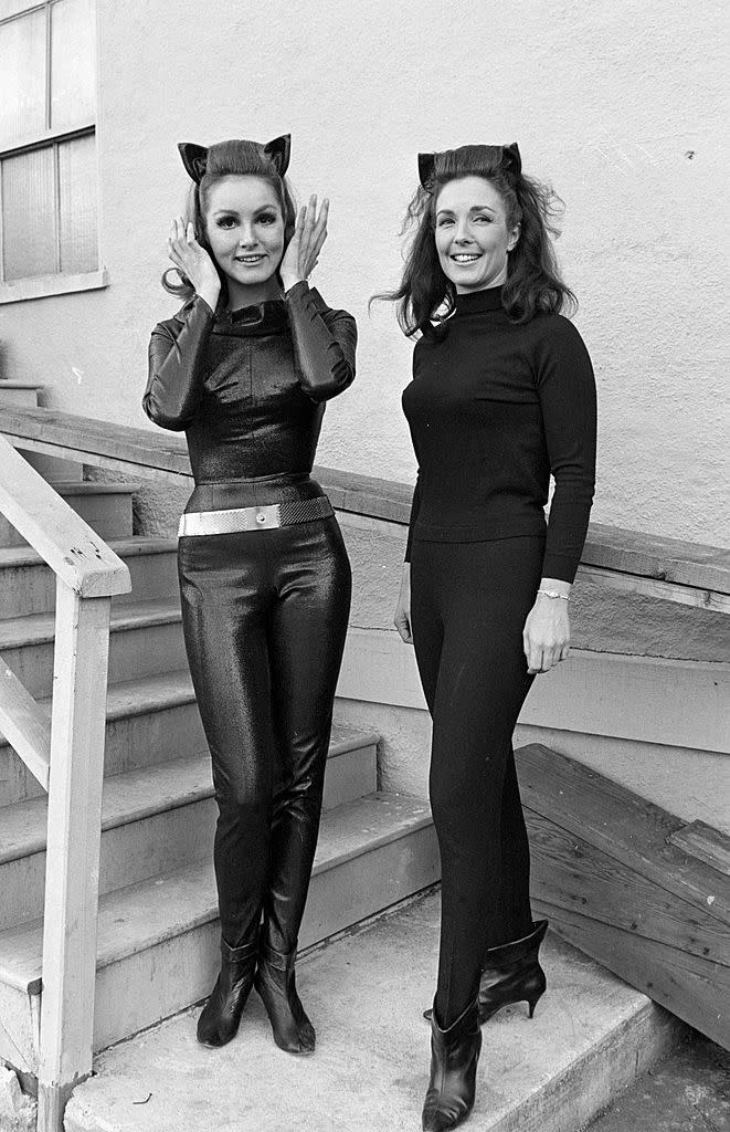 Julie Newmar and her stunt double dressed in a Catwoman costume with ears, the other in a turtleneck and tight pants