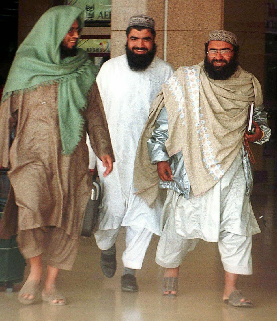 FILE - In this Jan. 22, 2000, file photo, leader of an outlawed Pakistani militant group Masood Azhar, right, walks with two unidentified people at the Karachi airport in Pakistan. In the world’s largest democracy, few issues reach as broad a consensus as Kashmir, that the Muslim-majority region must remain part of Hindu-majority India. Modi is using this, and a Feb. 14, 2019 attack on Indian paramilitary forces in Kashmir, to consolidate the Hindu vote in India’s five-week elections that conclude May 21 to bolster his campaign-slogan claim to be India’s chowkidar, or watchman. (AP Photo/Athar Hussain, File)