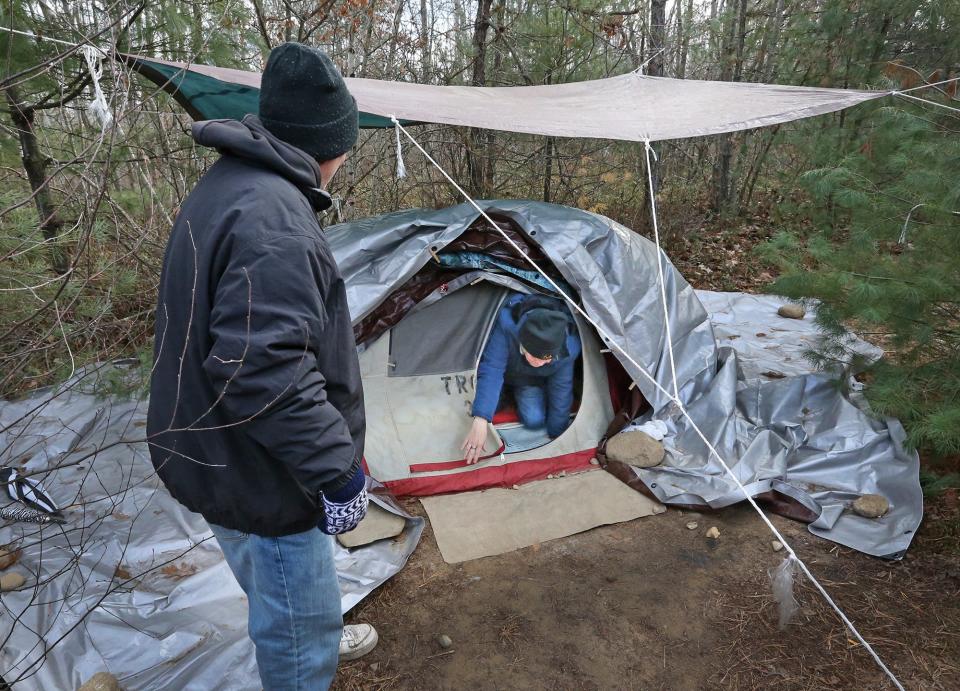 Jeff Sandler waits for his wife of 28 years, Tami, to crawl out of their tent in the woods of Sanford. The couple have been living outside for the last 10 months.