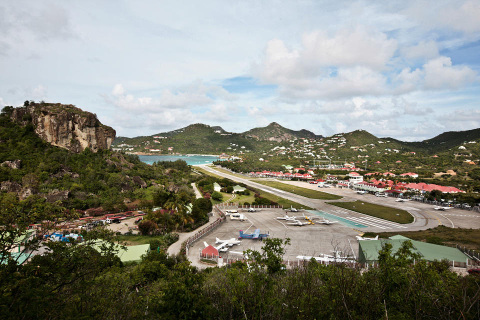 The famously terrifying landing between two hills aside, once you land all you see is lush greens and oceanside villas (oh and a beautiful beach, to boot).   (CYRIL FOLLIOT/AFP/Getty Images)